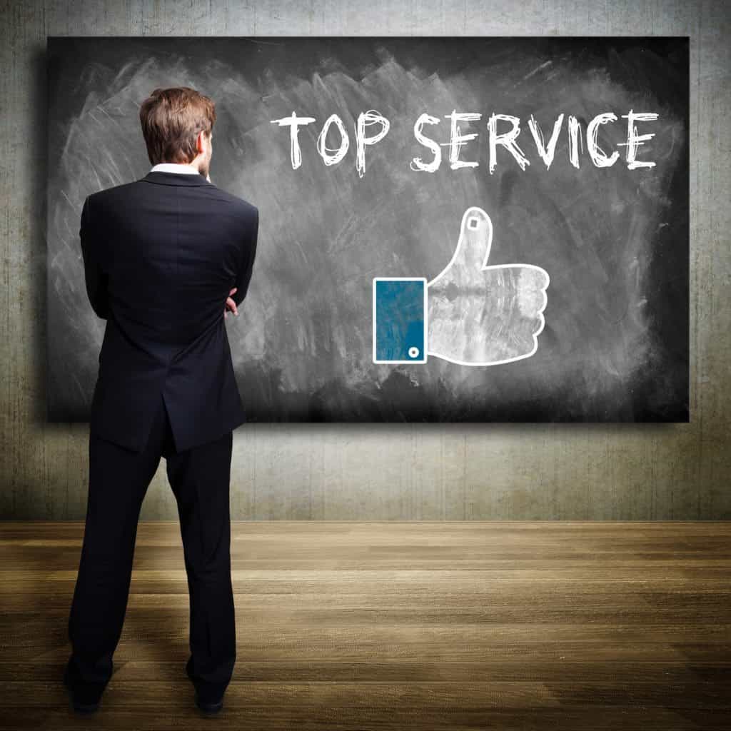 Ein wettbewerbsfähiges steht vor einer Tafel mit dem Wort „Top-Service“.
