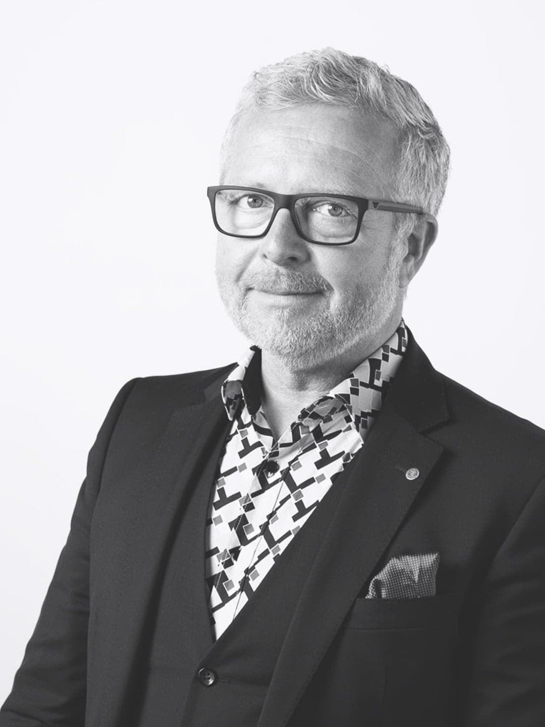 Stephan-Heinrich_Portraits_SW-004-hoch Ein Schwarz-Weiß-Foto eines Mannes mit Brille und Hemd.