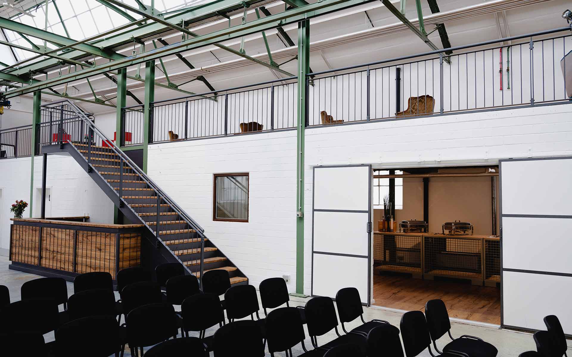 Ein Veranstaltungsort für Verkaufskonferenzen mit einem geräumigen Raum voller Stühle und einer Treppe.
