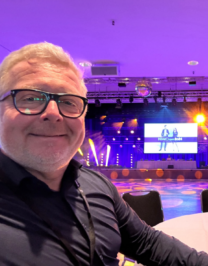 Mann macht ein Selfie bei einer Veranstaltung mit einer Bühne im Hintergrund und fängt den Moment erfolgreich ein. Mann macht ein Selfie bei einer Veranstaltung mit einer Bühne im Hintergrund und fängt den Moment erfolgreich ein.